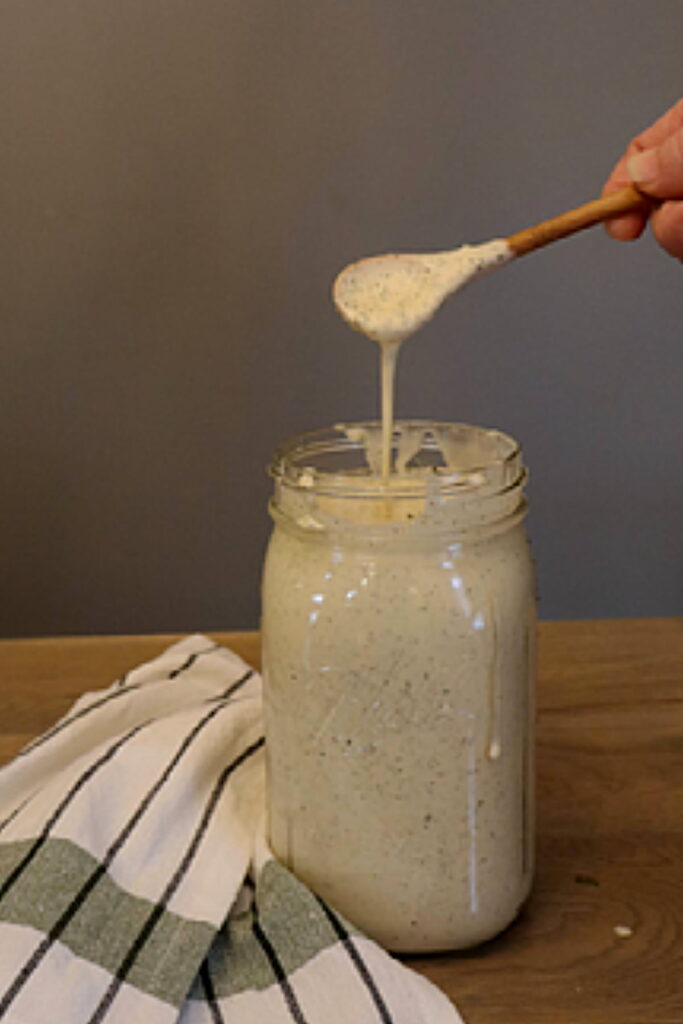 spoon drizzling ranch dressing back into the jar