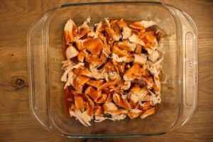 8x8 baking pan with chicken drizzled with hot sauce