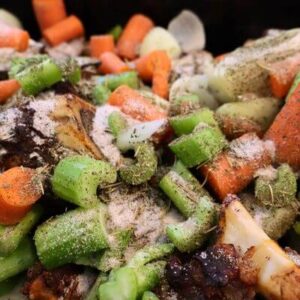 Chopped veggies and herbs Chopped vegetables and beef bones with salt and herbs sprinkled overtop
