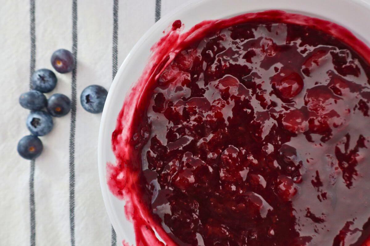 Easy 4-Ingredient Berry Sauce in a serving bowl with fresh blueberries