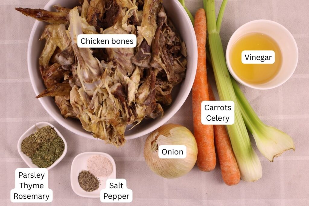 Ingredients for chicken bone broth. Roasted chicken bones, herbs, onion, celery, carrots, and applecider vinegar.