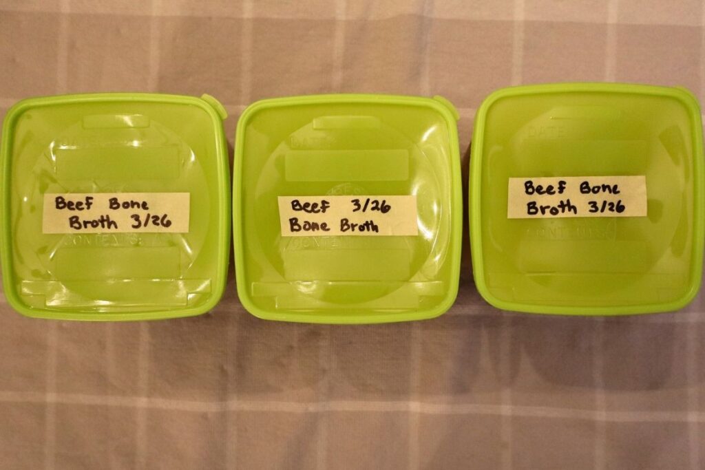 Containers of beef bone broth, labeled and ready to go in the freezer for soups, stews, sauces, and from-scratch recipes.