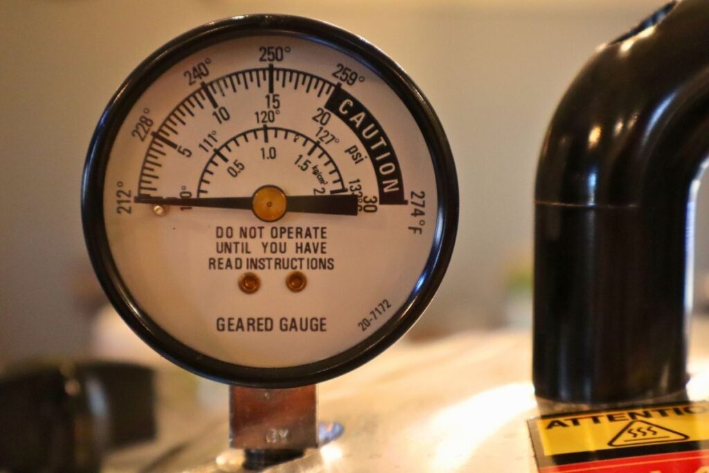 Pressure canner gauge showing no pressure and ready to remove the canner lid.