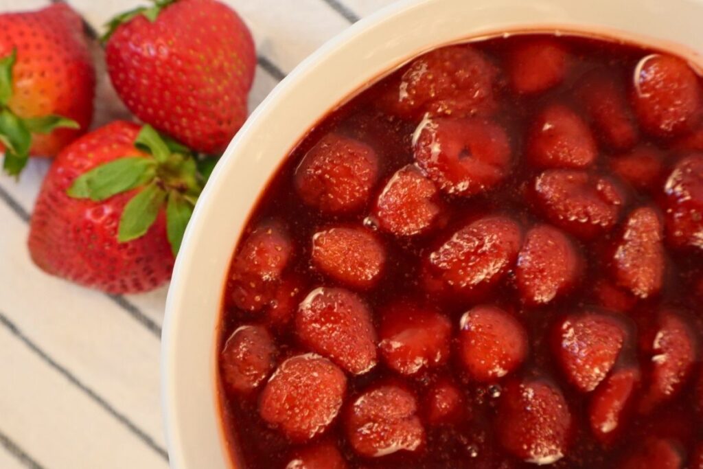 From-scratch strawberry sauce made with frozen strawberries in a bowl.