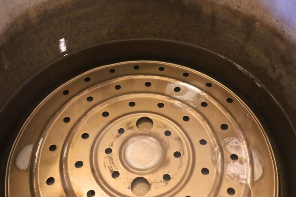 Water in a pressure canner with the rack in the bottom.