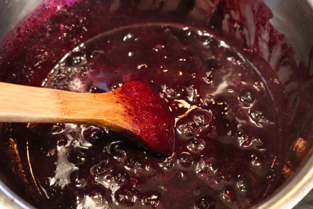 Blueberry sauce in the cloudy stage after adding the arrowroot slurry.