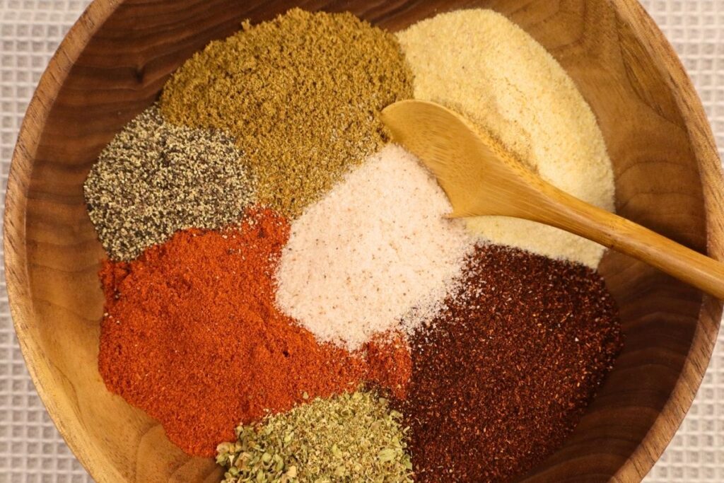 A bowl filled with taco seasoning spices with a spoon resting inside