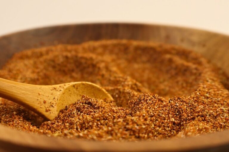 Closeup view of a bowl full of homemade taco seasoning with a wooden spoon.