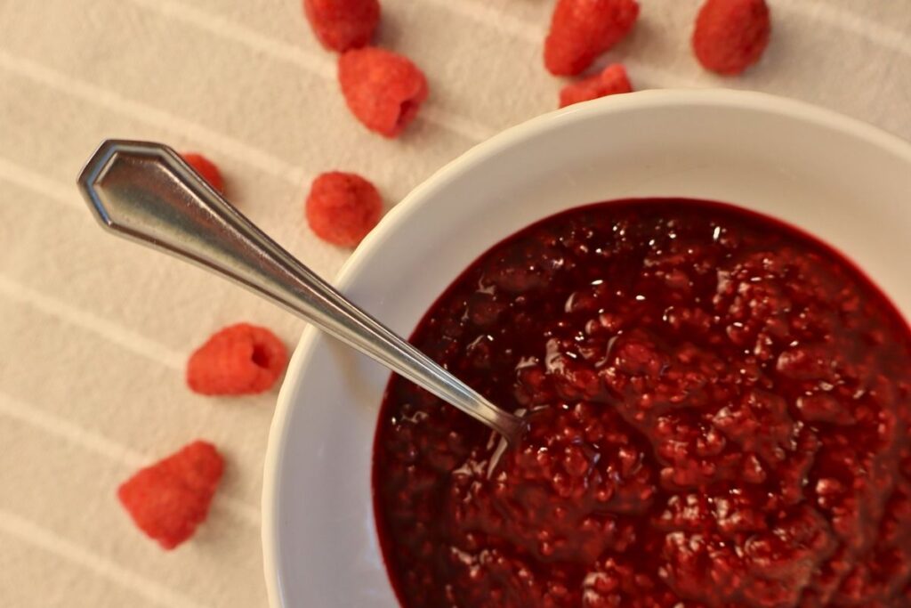How to Make Raspberry Sauce with Frozen Raspberries 17 Close-up view of raspberry sauce in a bowl.