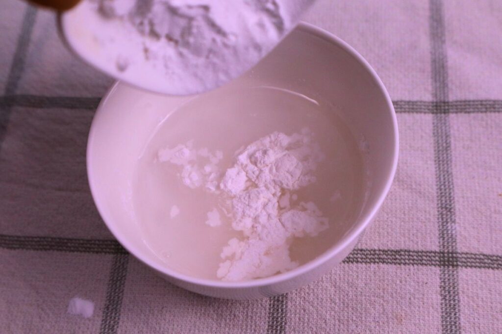 Arrowroot powder being mixed with water in a small bowl to make a slurry