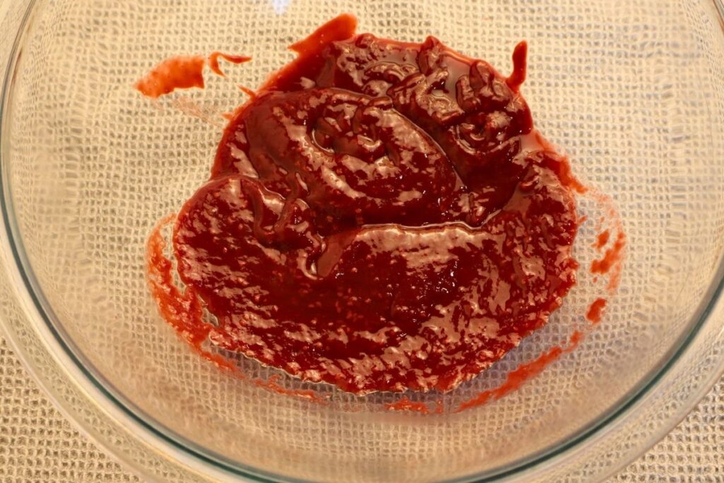 How to Make Raspberry Sauce with Frozen Raspberries 13 Smooth strained raspberry sauce in a bowl.