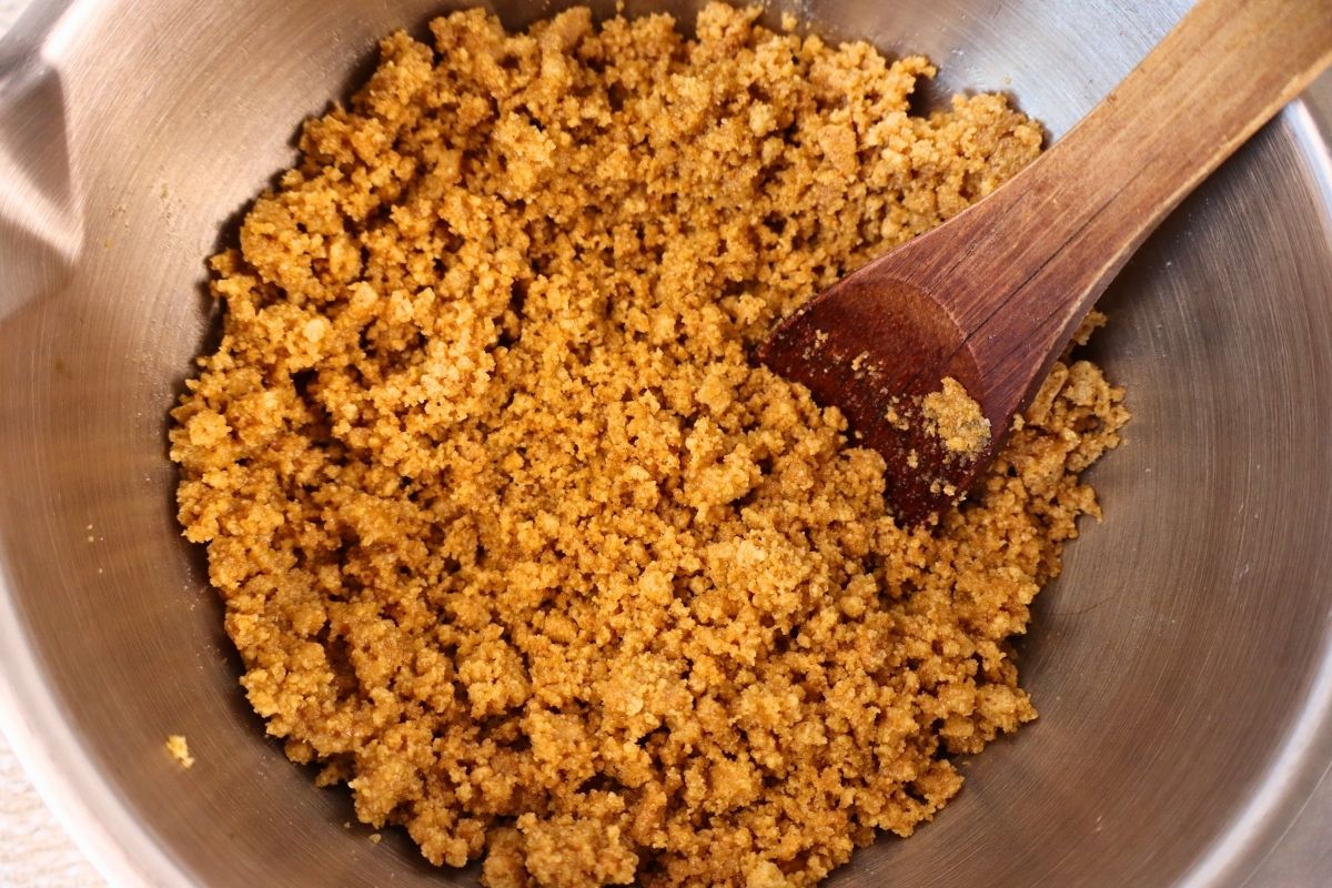Gluten-Free Mini No-Bake Cheesecakes with Berry Sauce 9 A mixing bowl with crushed homemade graham crackers and melted butter fully combined for the gluten free mini no bake cheesecake crust.