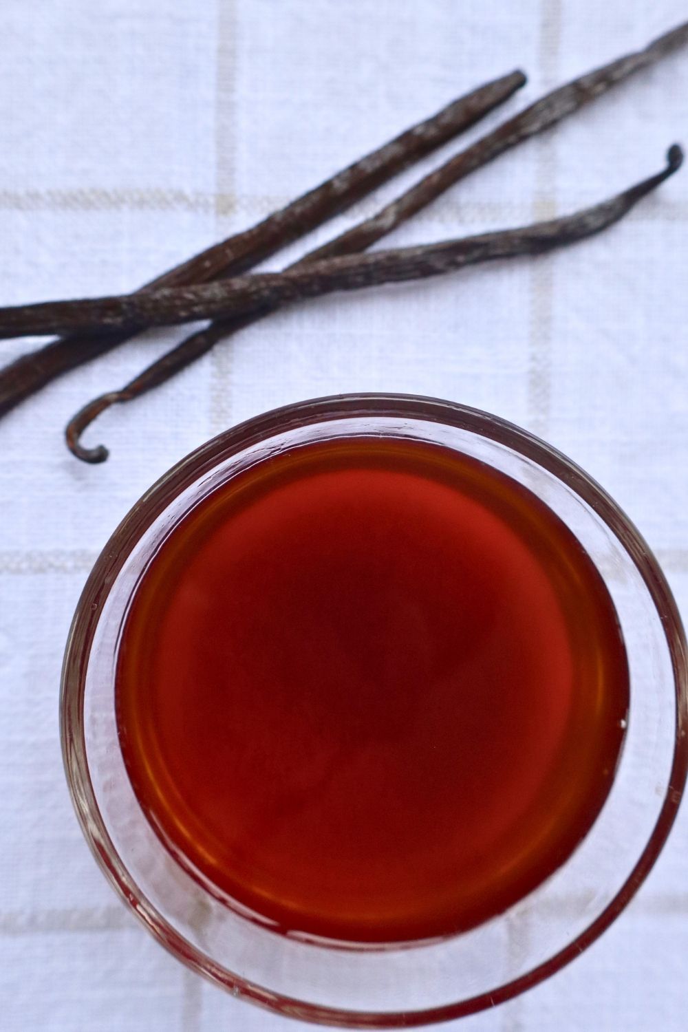 Large Batch Homemade Vanilla Extract Recipe with Vodka 2 Large Batch Homemade Vanilla Extract Recipe with Vodka — overhead shot of a bowl of rich homemade vanilla extract surrounded by whole vanilla beans
