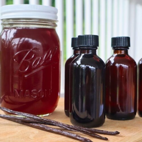 Large Batch Homemade Vanilla Extract Recipe with Vodka 16 Pint jar and small glass jars of homemade vanilla extract with vanilla beans in the foreground