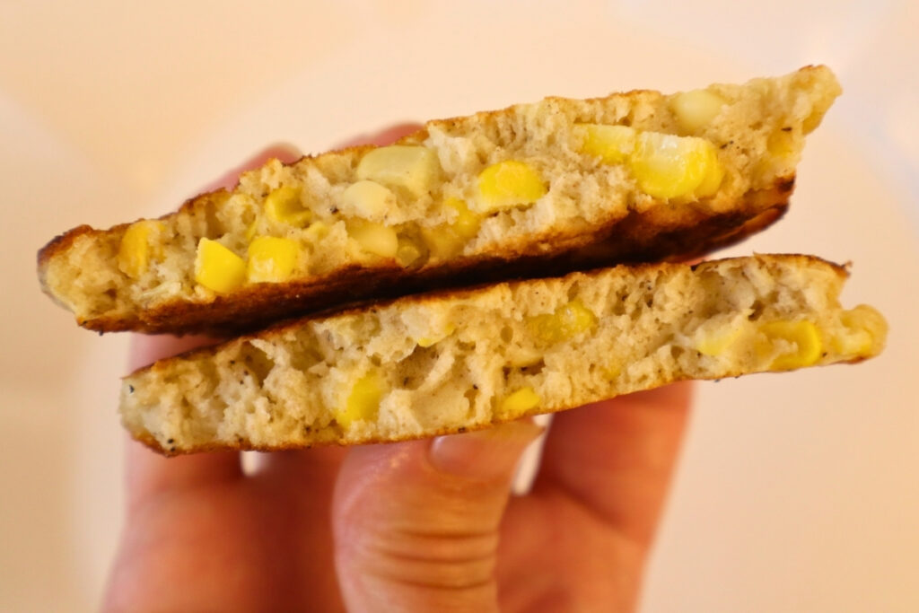 Gluten-Free Pennsylvania Dutch Corn Fritters 16 Gluten-free corn fritter split in half by hand, showing the texture and sweet corn kernels inside