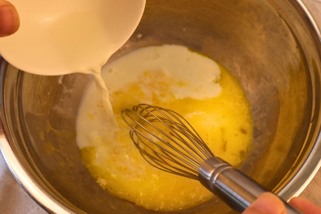 Gluten-Free Pennsylvania Dutch Corn Fritters 7 Pouring milk into whisked eggs and melted butter for gluten-free corn fritter batter