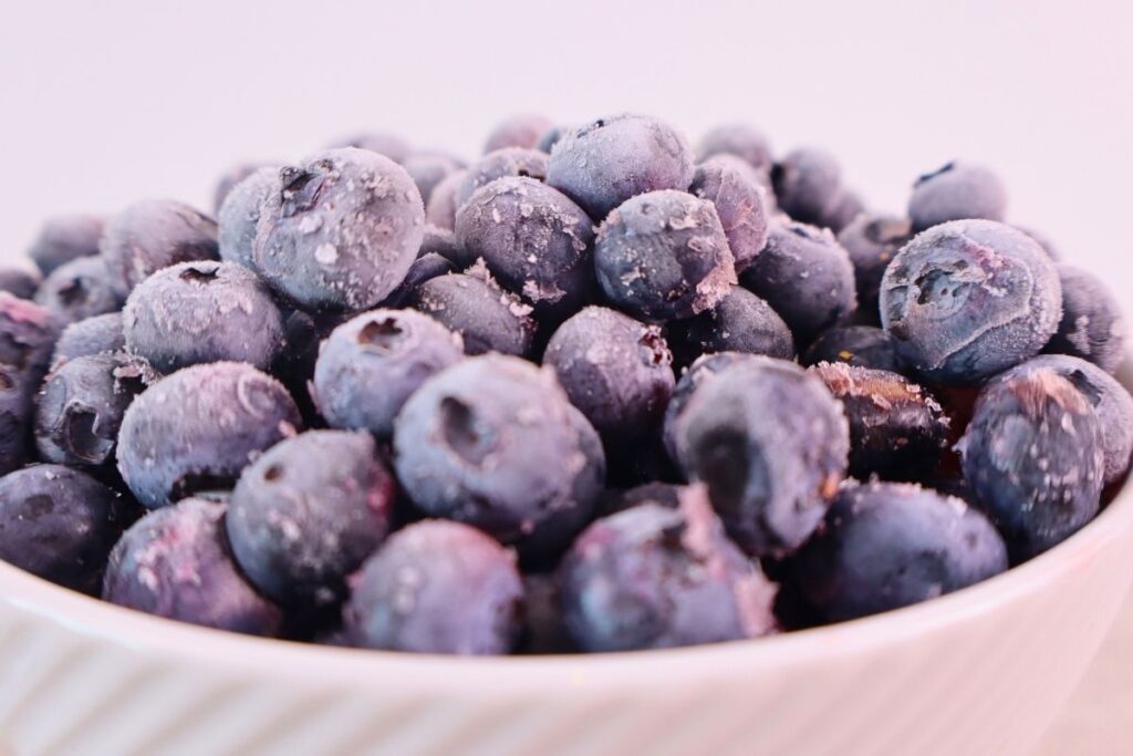 How to Freeze Fresh Blueberries for Year-Round Use 12 Close-up of frozen blueberries in a white bowl
