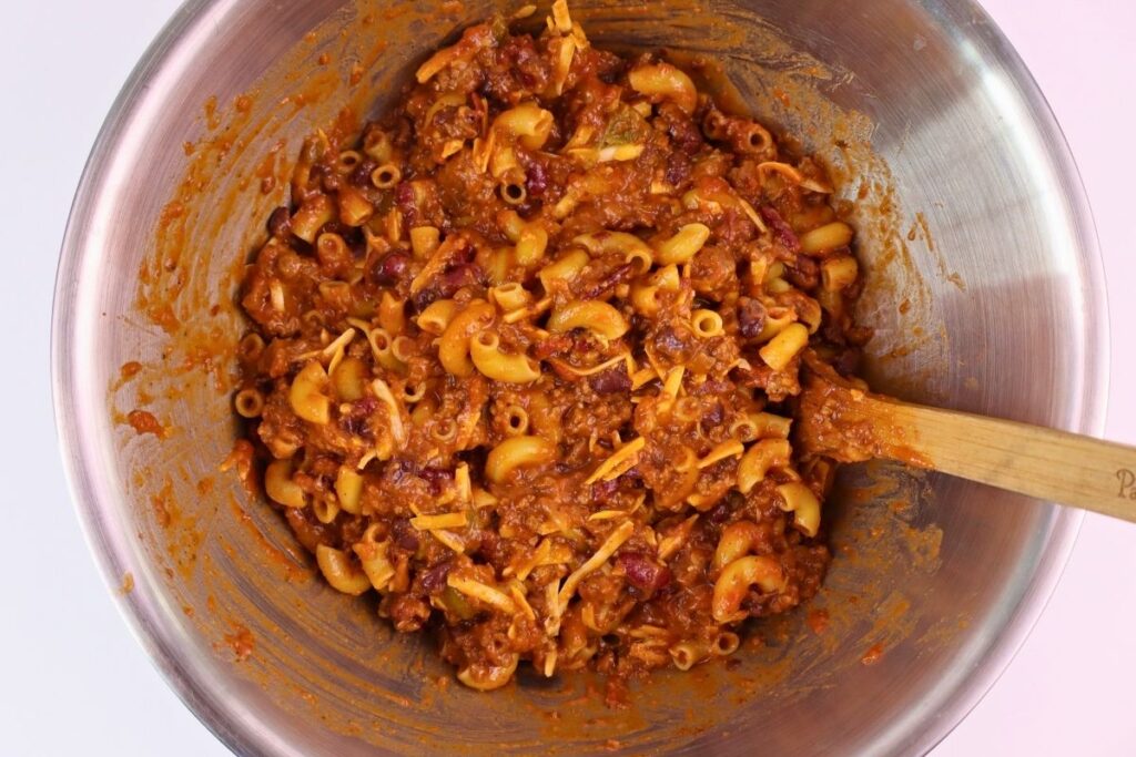 Easy Baked Gluten-Free Chili Mac 6 Gluten-free chili mac mixture stirred together with a wooden spoon in a stainless steel bowl
