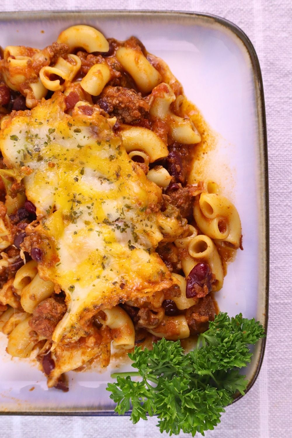 Easy Baked Gluten-Free Chili Mac 11 Gluten-Free Chili Mac plated and garnished with parsley, perfect for an easy weeknight dinner