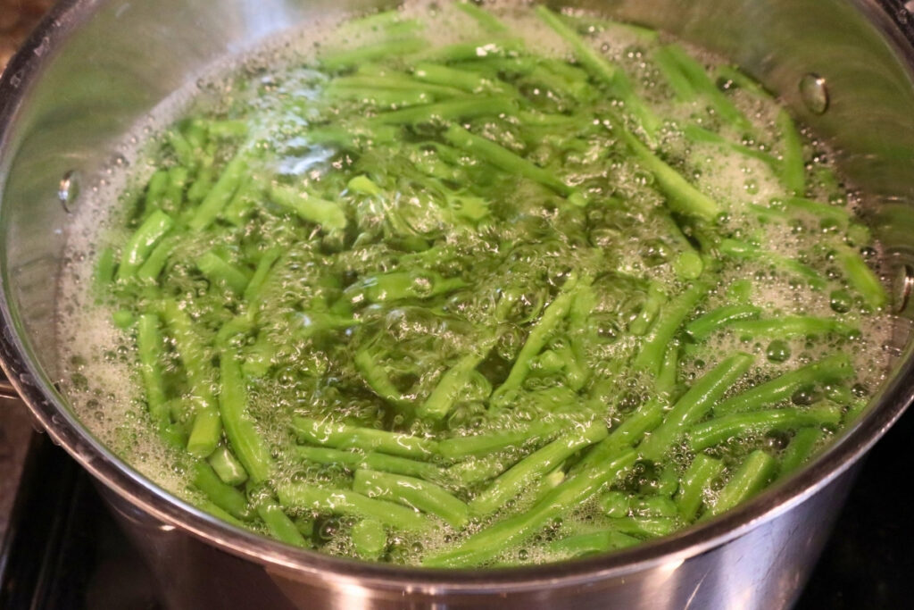 How to Freeze Fresh Green Beans From the Garden 9 Cut green beans boiling in a stainless steel pot to blanch before freezing