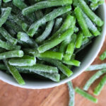 How to Freeze Fresh Green Beans From the Garden 14 White bowl of frozen green beans with frost, seen from above