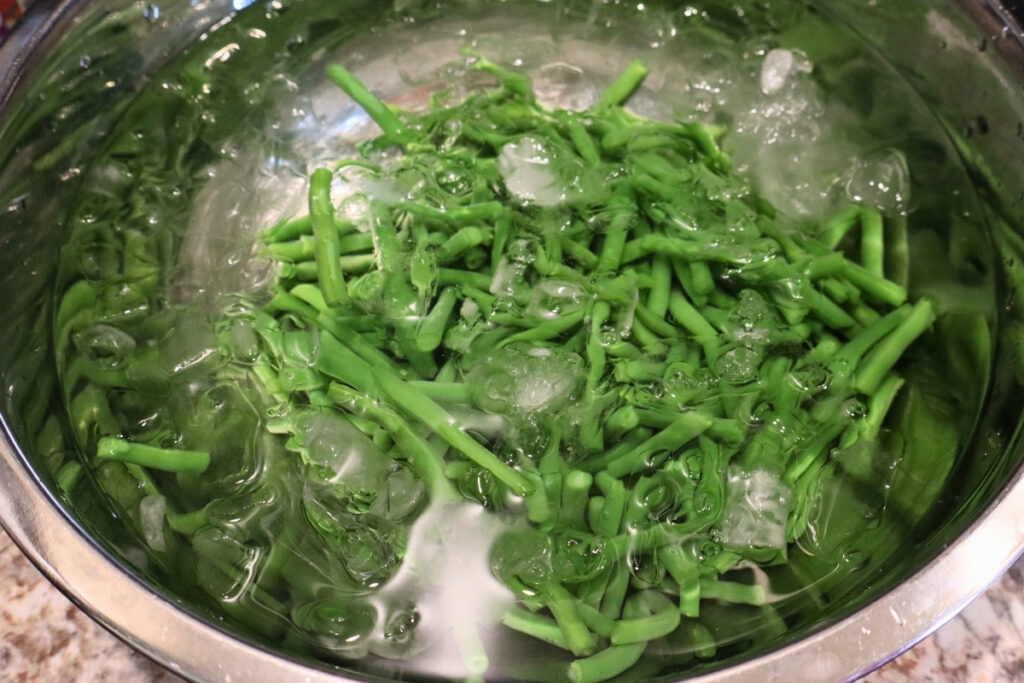 How to Freeze Fresh Green Beans From the Garden 10 Blanched green beans cooling in a bowl of ice water