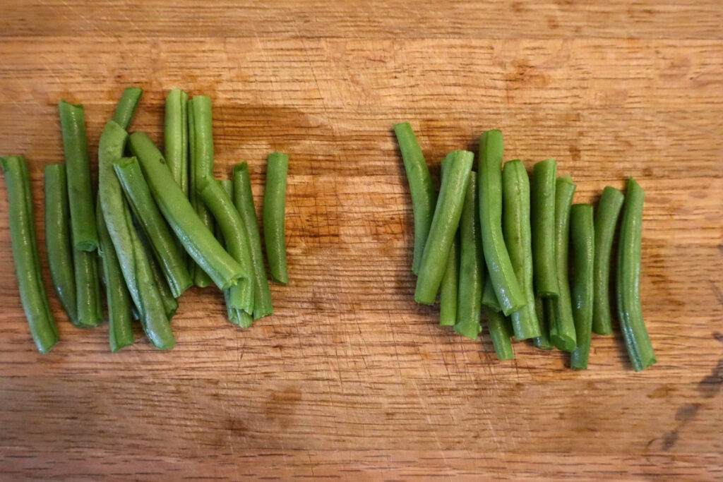 How to Freeze Fresh Green Beans From the Garden 8 Two piles of cut green beans on a wooden cutting board